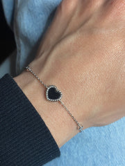 7 inches Sterling silver bracelet with black enamel heart and cubic zirconia accents worn on wrist