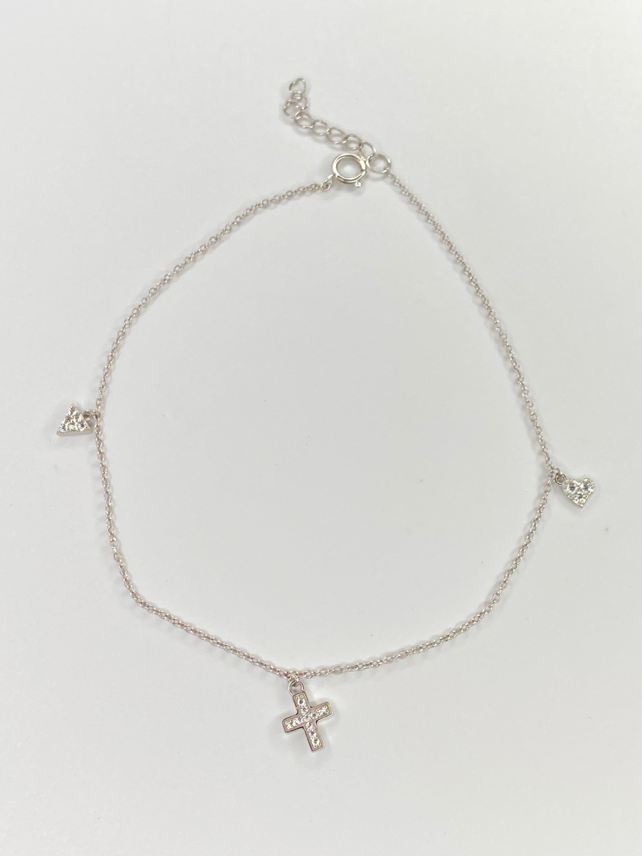 A delicate silver chain anklet with three small cross charms, displayed on a clean white background.