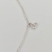 A delicate silver chain anklet with a small pavé-set heart pendant, shown on a plain light gray background.