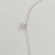 A delicate silver chain anklet featuring a small triangular pendant paved with clear cubic zirconias, displayed on a plain light gray background.