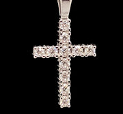 A silver cross pendant encrusted with clear moisanite  stones, displayed on a textured black background.
