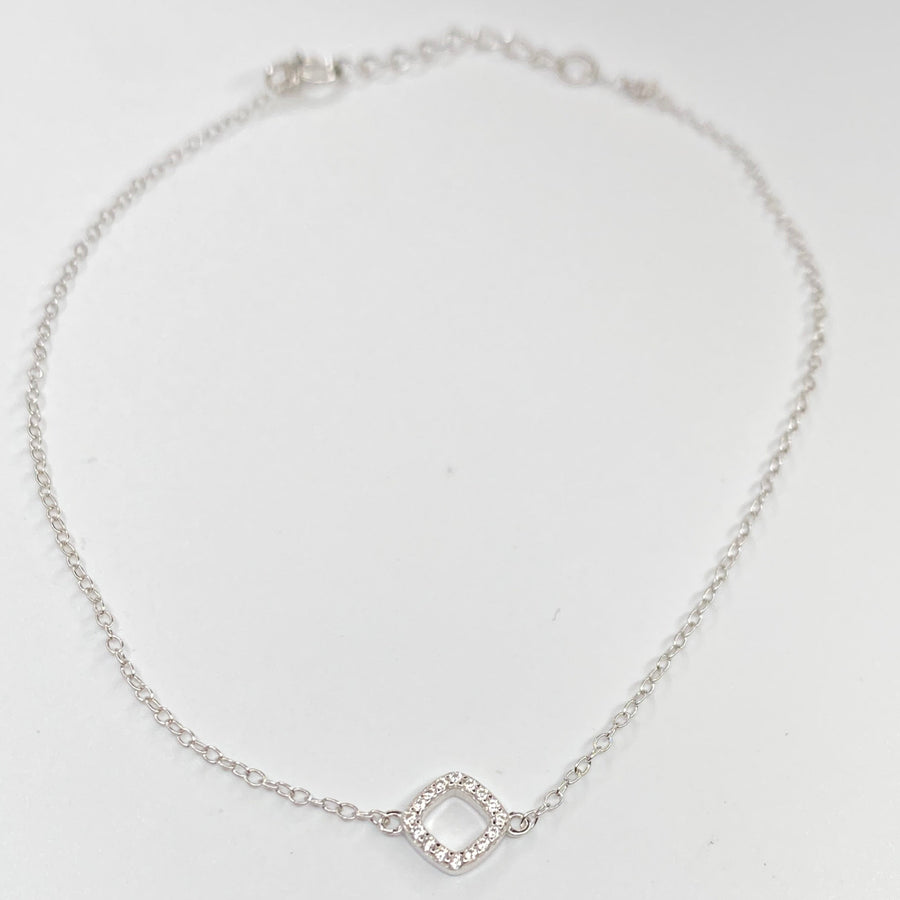 A delicate silver chain anklet featuring a small open diamond-shaped charm paved with tiny clear cubic zirconias, displayed on a clean white background.