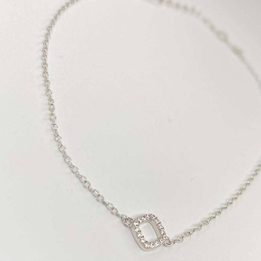 A delicate silver chain anklet featuring a small square charm encrusted with clear cubic zirconias, displayed on a clean white background.