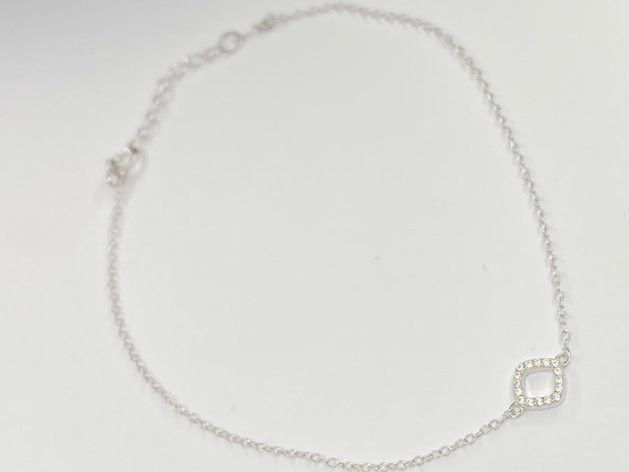 A delicate silver chain anklet with a small square link charm, displayed on a plain white background.